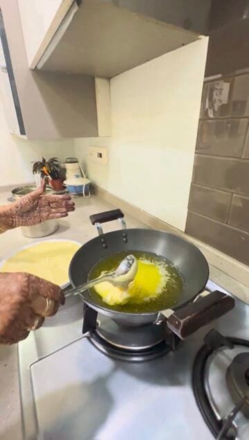Adding ground moong dal to ghee in wok