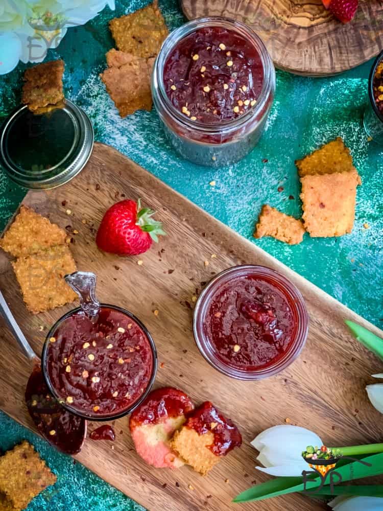 Top down view of Strawberry ginger chutney in a jar decorated on a platter.