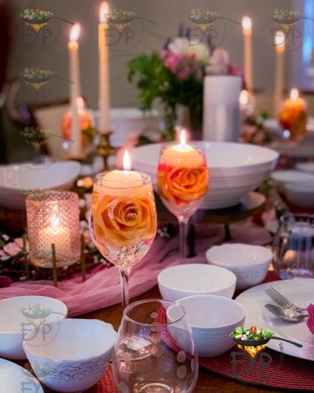 Wine glasses with floating candles and rose for valentine day table setting